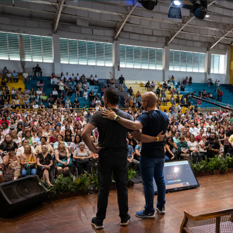 Palestrantes no palco diante do público lotado