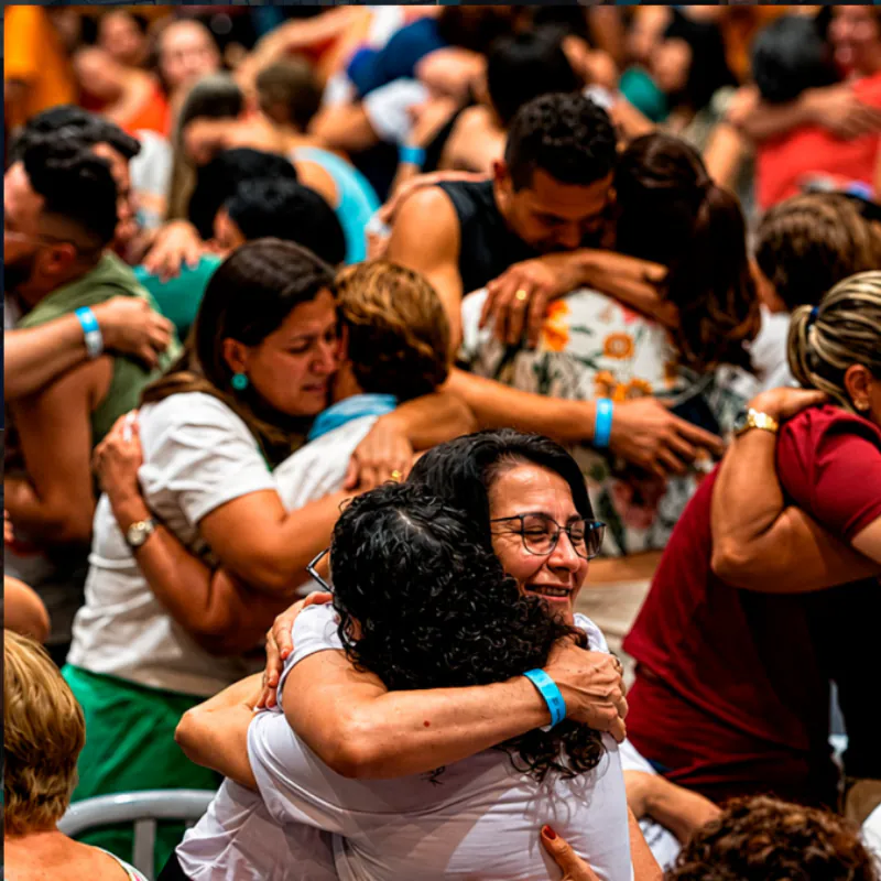 Participantes se abraçando emocionados durante o congresso