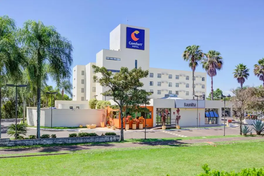 Fachada do Comfort Hotel Franca, com jardim e palmeiras à frente